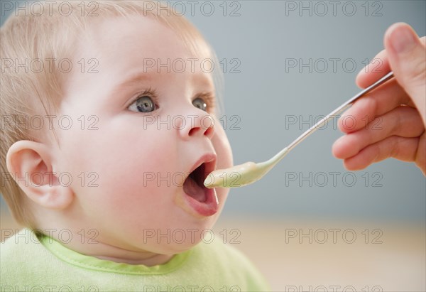 Mother feeding Caucasian baby