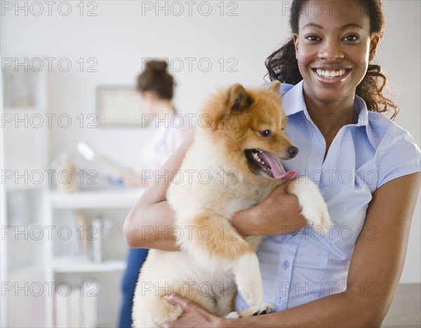 Mixed race woman holding Pomeranian dog