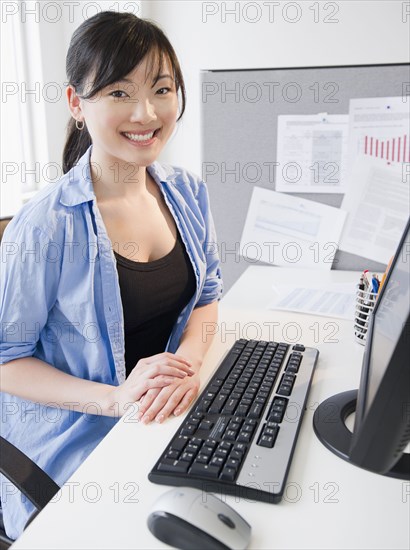 Korean woman sitting at desk with computer