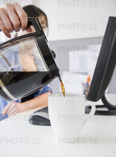 Korean woman pouring coffee at desk