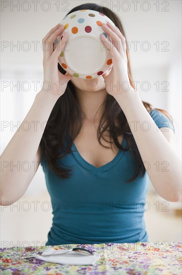 Korean woman drinking from bowl