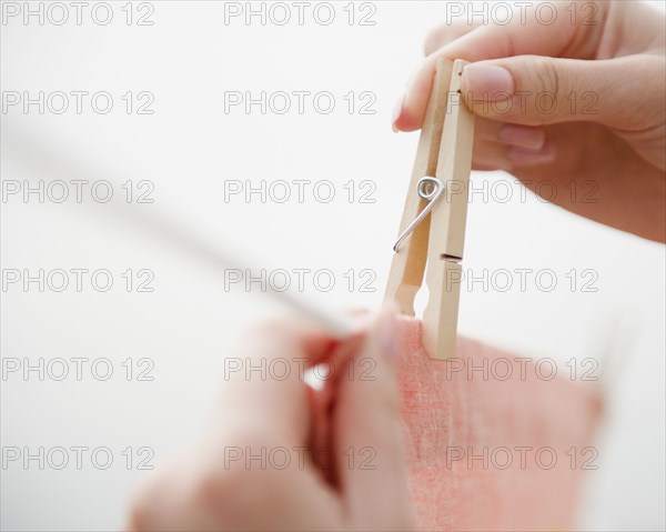 Korean woman hanging clothing on clothes line