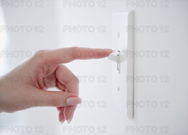 Korean woman turning off light switch