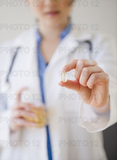 Korean doctor holding out capsule
