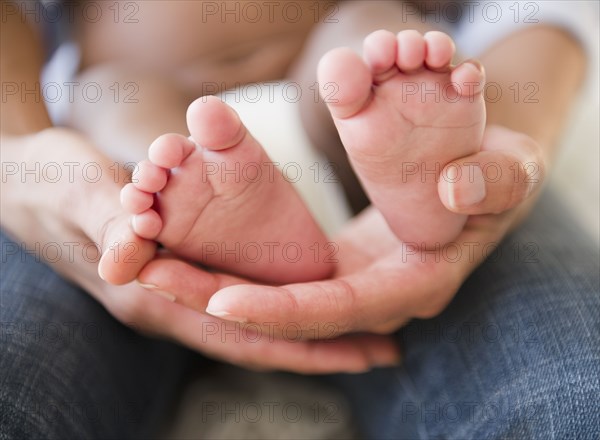 Close up of African American mother holding baby's feet