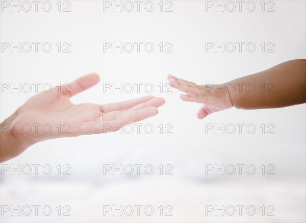 African American woman reaching out to baby boy