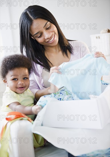 African American mother and baby boy opening gift