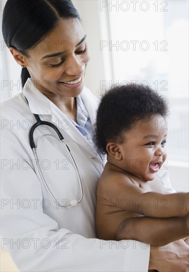 African American doctor holding baby boy