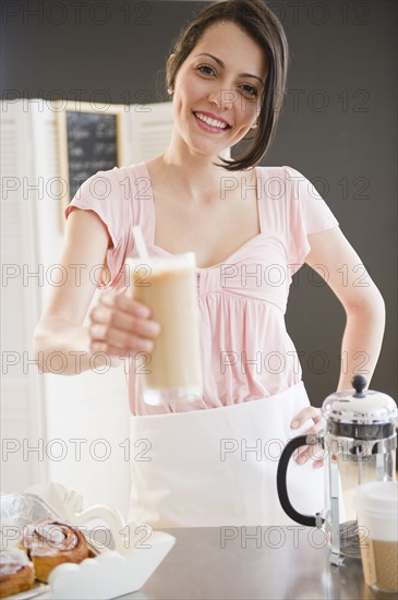 Brazilian waitress holding out iced coffee
