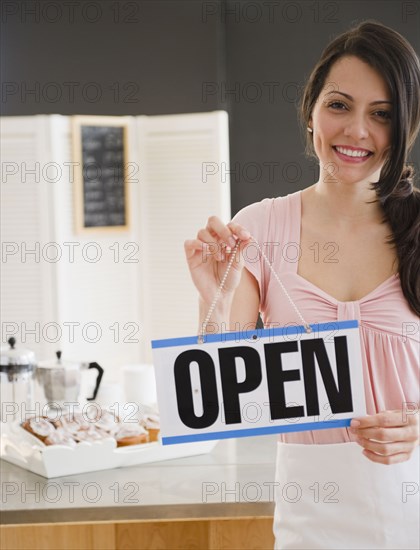 Brazilian woman holding open sign