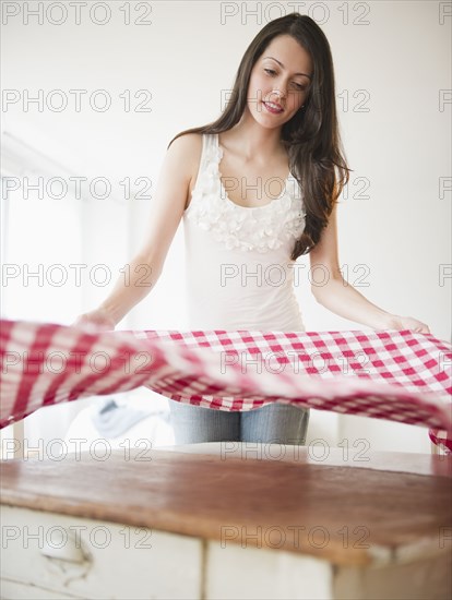 Brazilian woman spreading tablecloth
