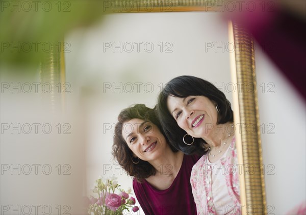 Mother and daughter looking in mirror