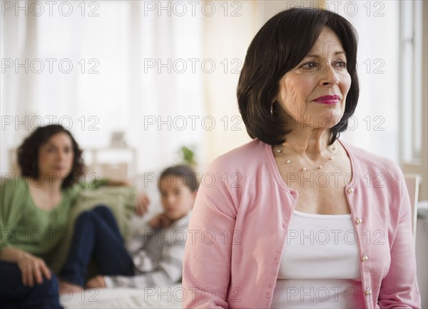 Serious woman with family in background