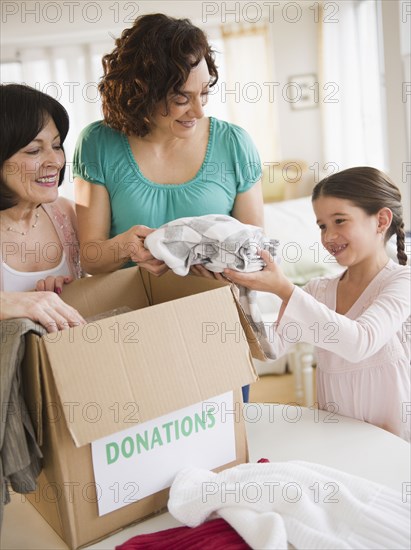 Family packing box of clothing donations