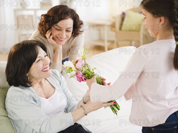 Granddaughter giving grandmother bouquet of flowers