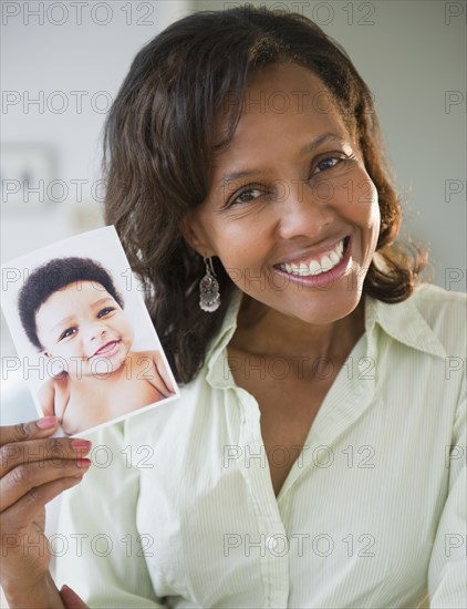 Black woman holding photograph of baby