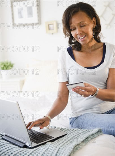 Black woman shopping online with credit card