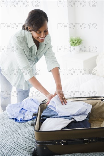 Black woman packing suitcase