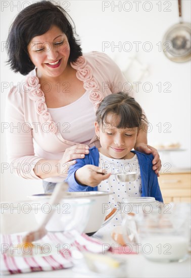 Hispanic mother and daughter baking together