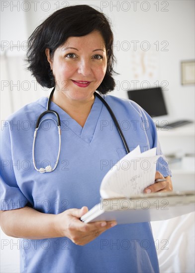 Hispanic doctor looking at medical chart