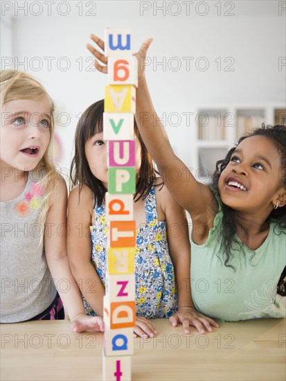 Girls stacking alphabet blocks together