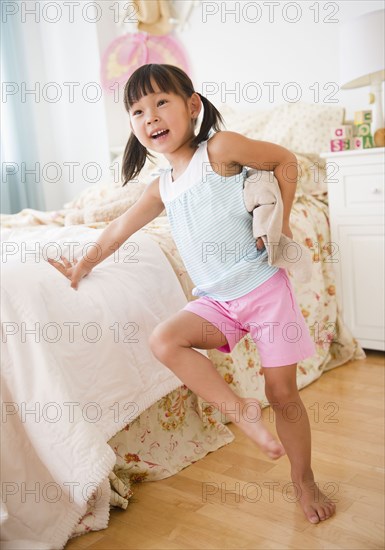 Korean girl leaning against bed in bedroom