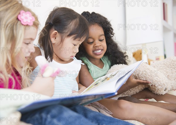 Girls reading book together