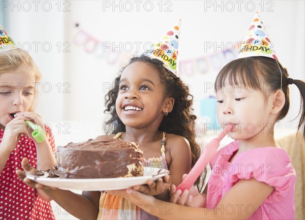 Girls holding birthday cake together