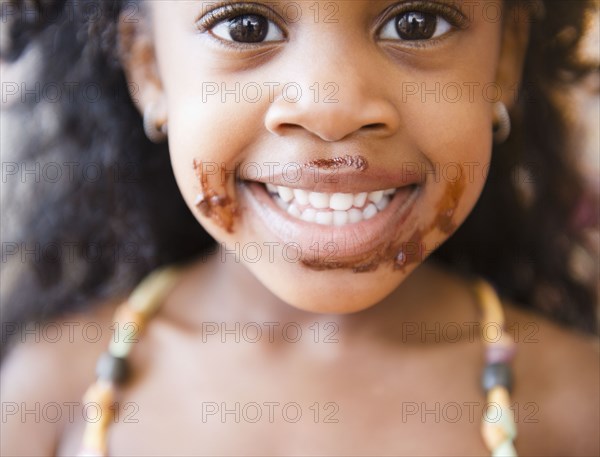 Mixed race girl with chocolate on her face