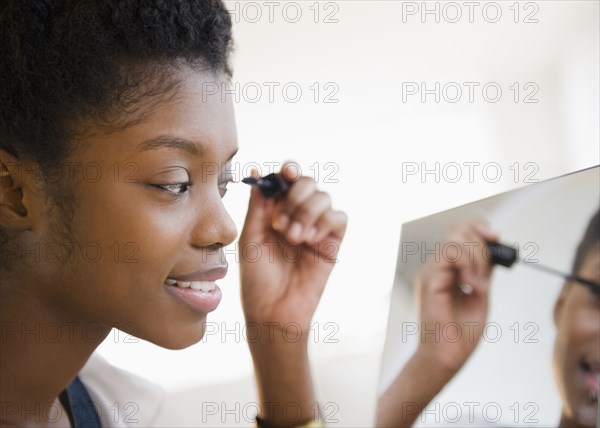 Black woman putting on mascara