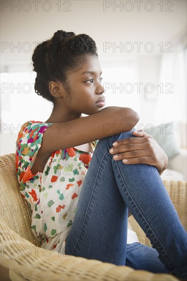 Serious Black woman sitting in chair