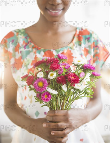 Black woman holding bouquet of flowers