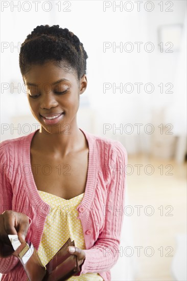 Black woman taking money out of her wallet