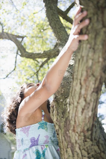 Hispanic girl climbing tree