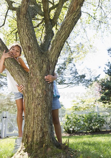 Hispanic children playing near tree