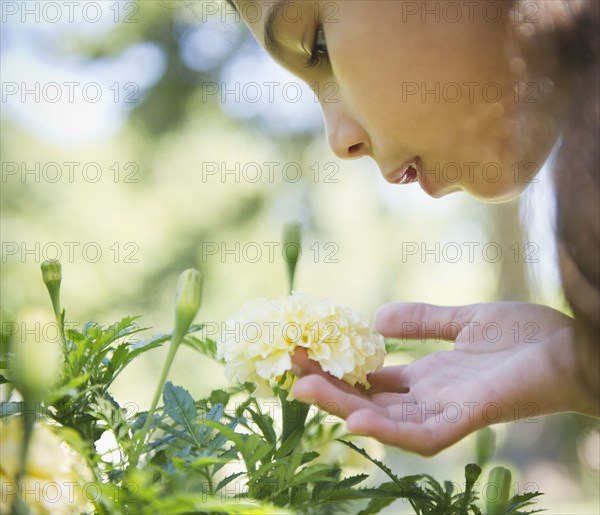 Hispanic girl smelling flower