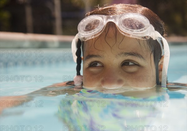 Hispanic girl swimming in swimming pool