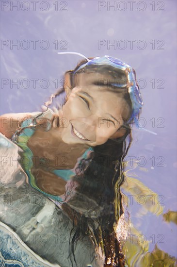 Hispanic girl looking into swimming pool