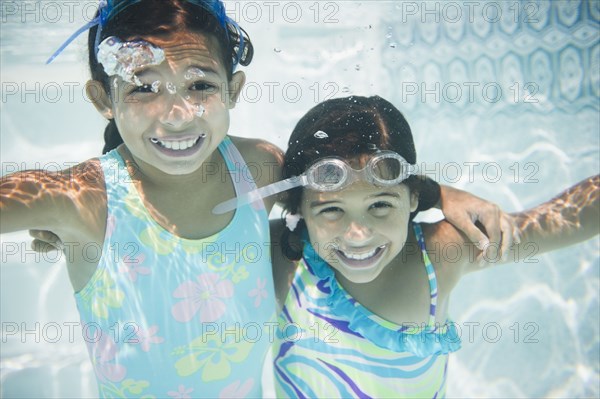 Hispanic girls swimming under water