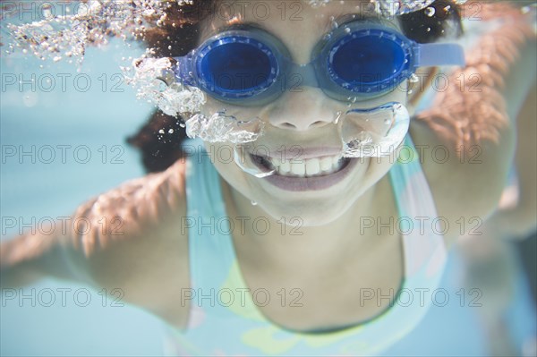 Hispanic girl swimming under water