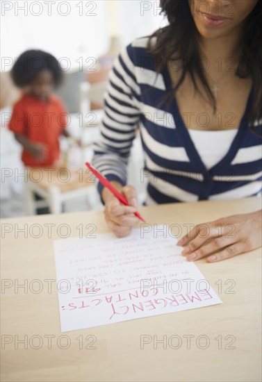 African American woman writing out contact phone numbers