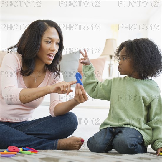 African American mother teaching son numbers