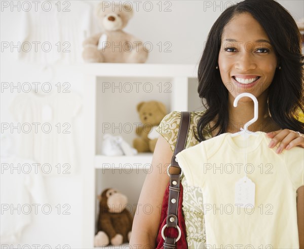 African American woman holding baby clothing