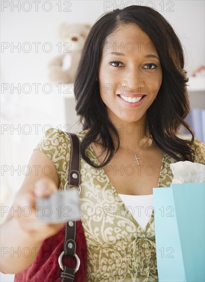 African American woman in store paying with credit card