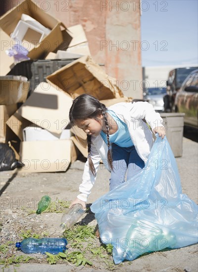 Korean girl picking up plastic bottles