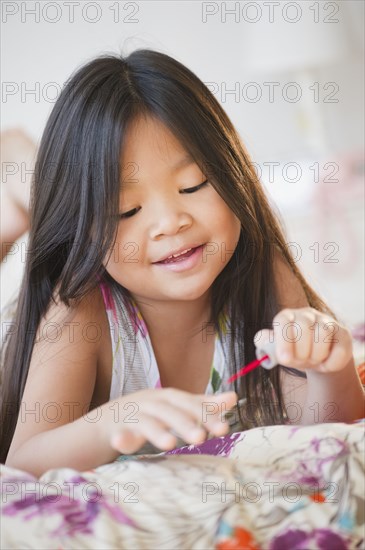 Korean girl putting on fingernail polish