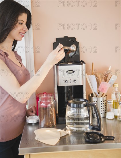 Mixed race woman making coffee