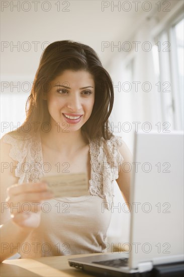 Mixed race woman shopping online with credit card