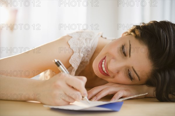 Mixed race woman writing on birthday card