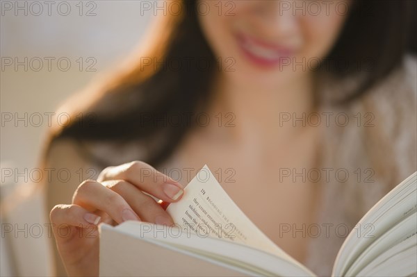 Mixed race woman reading book